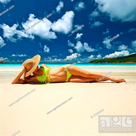 Woman In Yellow Bikini Lying On Beach At Seychelles Stock Photo