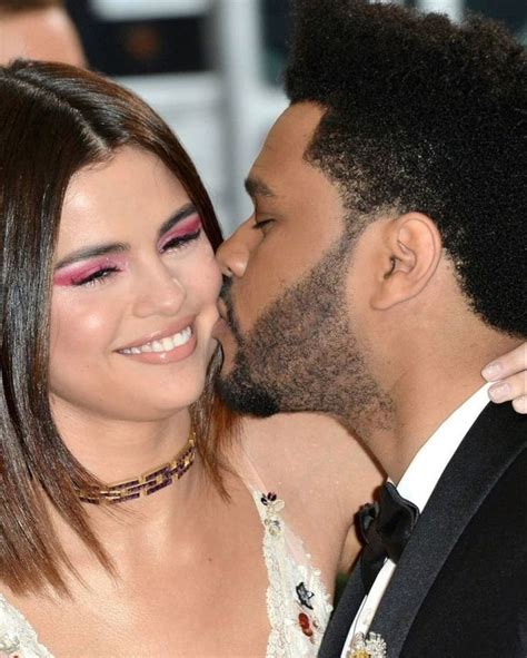 A Couple Kissing Each Other On The Red Carpet