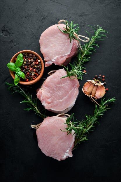 Premium Photo Raw Meat Medallions With Rosemary And Spices On A Black