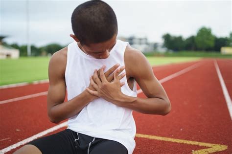 Atletas asiáticos deportistas corredores sentados con dolor en el pecho