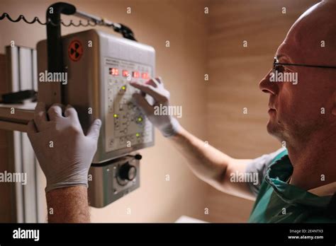 Mature Engineer Working With Electric Equipment Hanging On The Wall