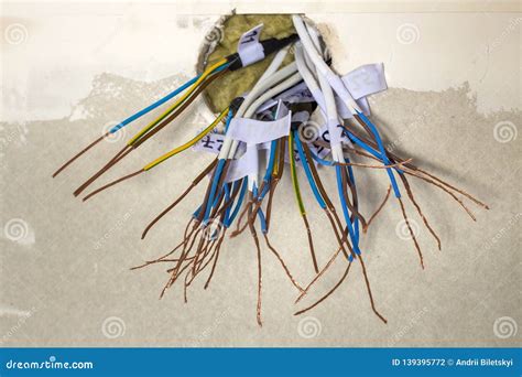 Electrical Exposed Connected Wires Protruding From Socket On White Wall