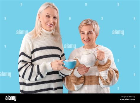Mature Women Pouring Tea Into Cup On Blue Background Stock Photo Alamy