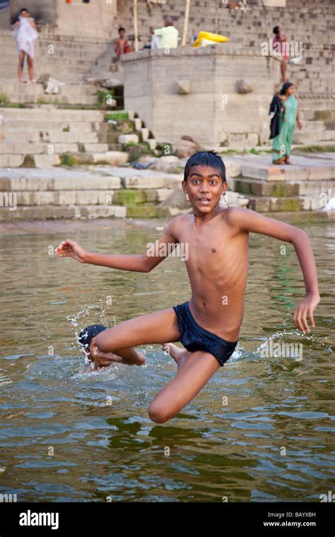 Hindu Boy Jumping From Shoulders Into The Ganges River In Varanasi