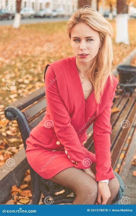 Portrait Of A Blonde Next To A Red Orange Bush In Autumn The Concept Of The Autumn Season Stock