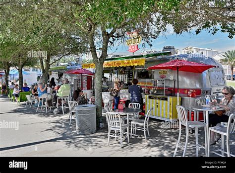 Food truck or trucks, with families or a family eating, at the beach ...