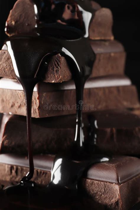 Melted Chocolate Pouring Into A Piece Of Chocolate Bars Stock Photo