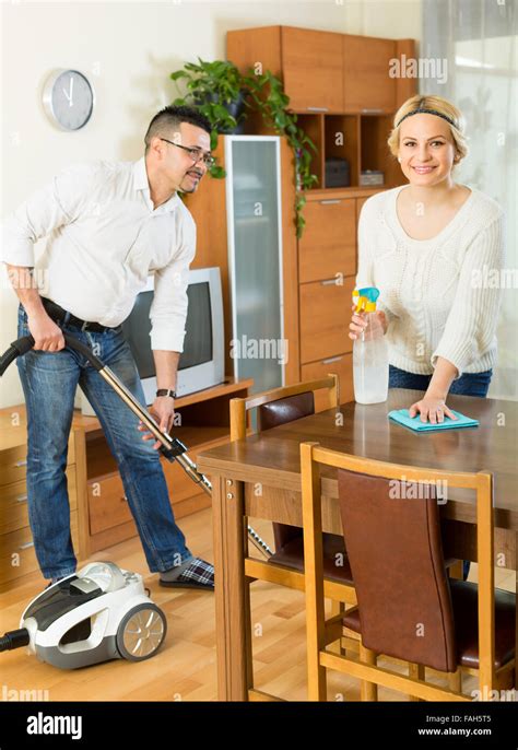 Cheerful Husband Helping His Wife Cleaning The Room Focus On Woman