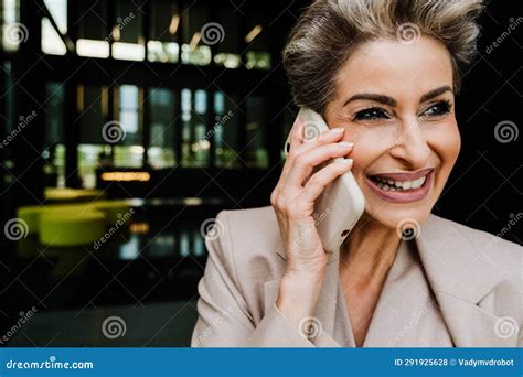 Mature Grey Woman Laughing While Talking On Mobile Phone Stock Photo