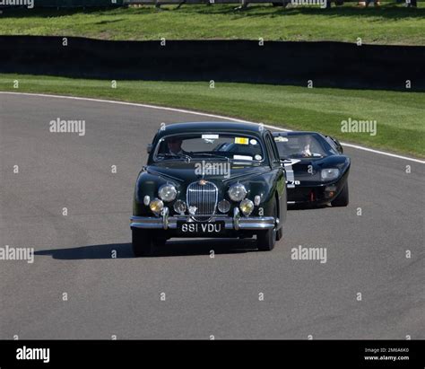 A Green 1958 Jaguar Saloon Leads A Ford Gt40 At The 2022 Goodwood