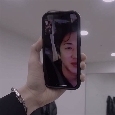 A Person Holding Up A Cell Phone To Take A Selfie With The Image Of A