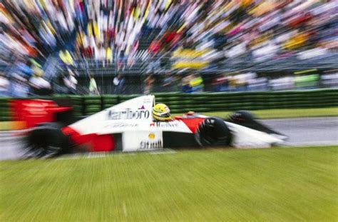 A Red And White Race Car Speeding Down The Track