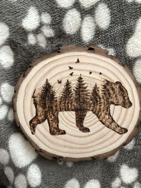 A Bear And Birds Carved Into A Wood Slice On A Polka Dot Blanket With