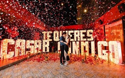 Two People Standing In Front Of A Sign With Confetti On It