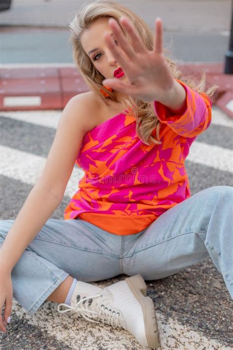 Stop Hand Gesture Spectacular Blonde In Bright Blouse Jeans Sits On