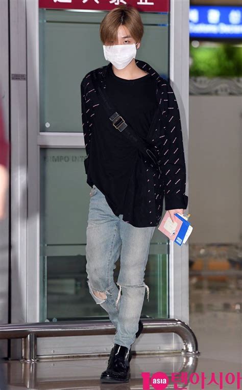 A Man Wearing A Face Mask While Standing In Front Of An Airport