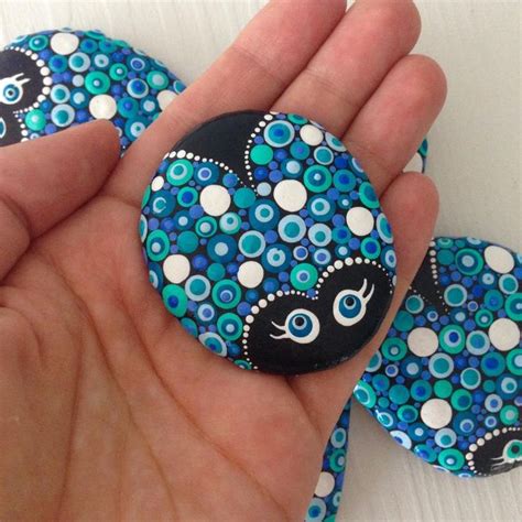 A Hand Holding A Blue And White Button With An Octopus On It S Face