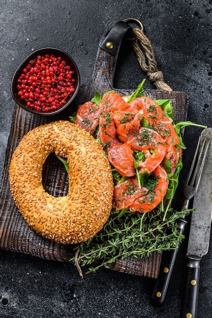 Bagel de salmón ahumado con queso tierno rúcula sobre una tabla de