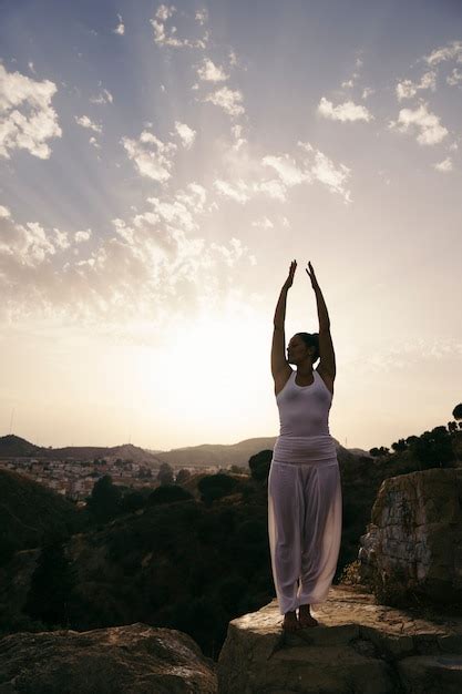 Mujer En Pose De Yoga Con Las Manos Arriba Foto Gratis