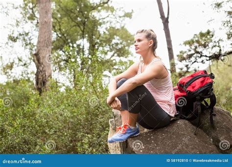 Blonde Hiker Sitting On Rock And Viewing The Landscape Stock Photo