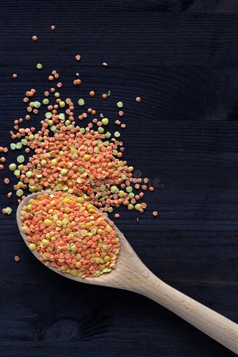 Wooden Spoon With Dried Red And Yellow Lentils On A Wooden Table Stock