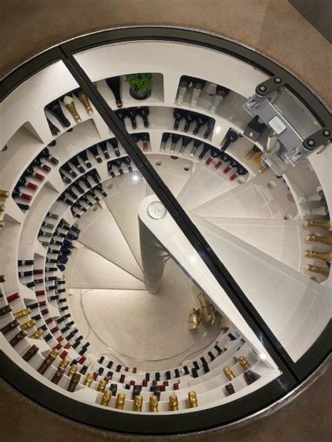 A Spiral Staircase With Lots Of Wine Bottles On The Wall And In The