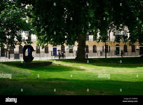 Looking Through The Gardens Of Fitzroy Square To View Sculpture By