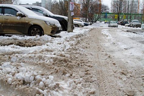 A Pile Of Dirty Snow On The Parking Near The Cars In The Yard Editorial