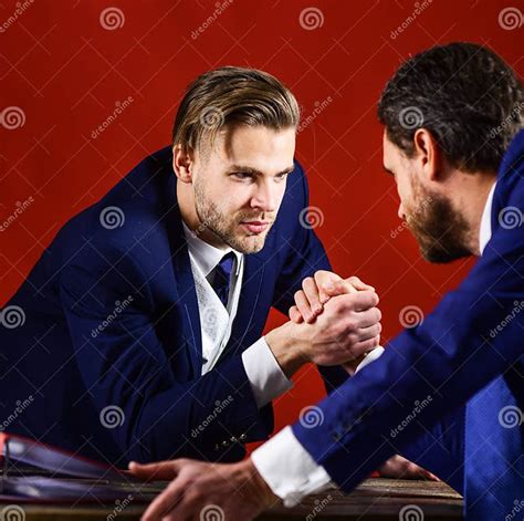 Waist Up Portrait Of Two Angry Businessmen In Suits Armwrestling Stock