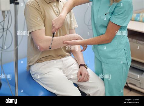 Female Neurologist Checking Patient Health With Instrument Stock Photo