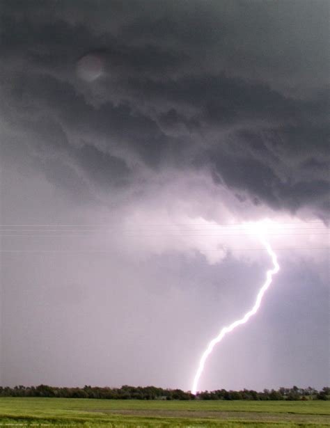 Lightning from a tornadic thunderstorm passing over Clearwater, Kansas strikes at an open field