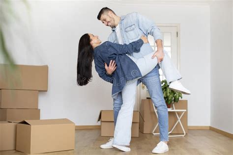 Romantic Young Couple Dancing In Room With Cardboard Boxes On Moving