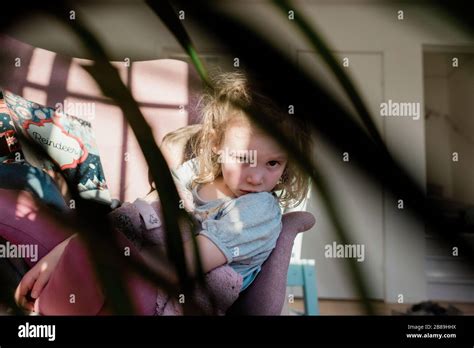 vista de un niño sentado en una silla en casa leyendo con su hermano