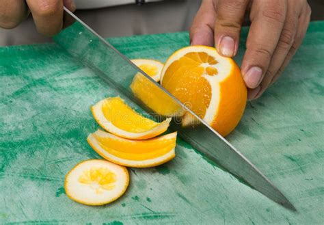 A Vibrant Orange Organic Juicy Orange Being Sliced Into Segments Stock