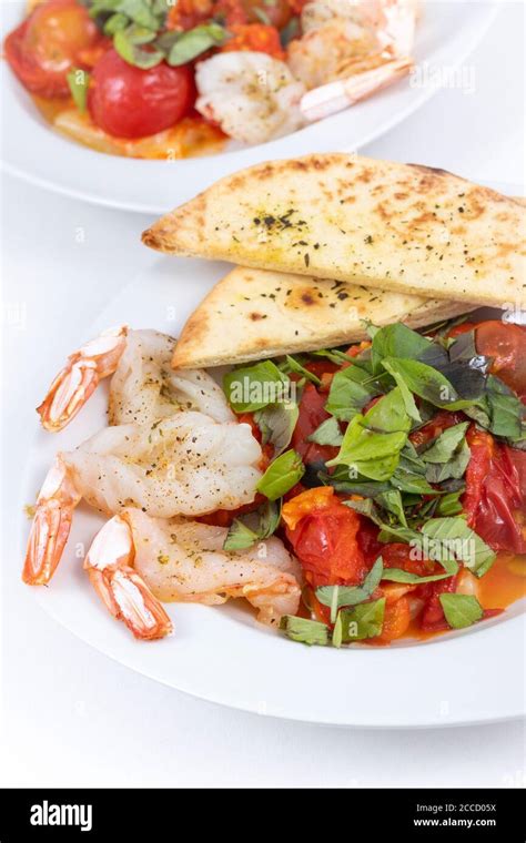 Garlic Butterfly Prawn With Roasted Tomatoes Dish Stock Photo Alamy
