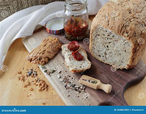 Loaf Of Homemade Whole Grain Bread And A Cut Slice Of Bread On A Wooden