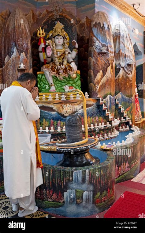 Un sacerdote Hindú rezando y meditando delante de un lingam y semejanza