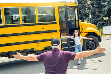 Father Meeting Daughter Running Out Of School Bus Smiling Happy Stock