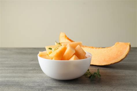 Recipiente con trozos de melón en mesa con textura gris Foto Premium