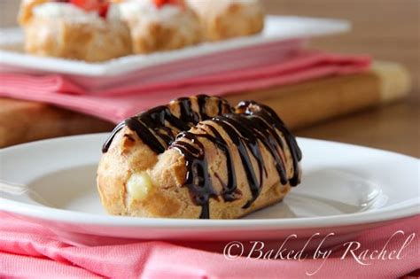 two pastries with chocolate drizzled on them sitting on a white plate