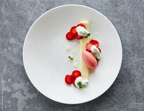 A White Plate Topped With Food On Top Of A Gray Table Next To A Knife And Fork