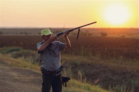 Un Hombre Con Una Pistola En Sus Manos Y Un Chaleco Verde En Una Caza