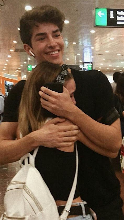 A Man And Woman Hugging Each Other In An Airport