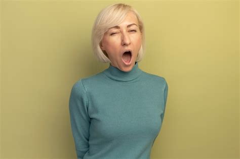 Joyeuse Jolie Blonde Femme Slave Clignote Des Yeux Isol Sur Mur Vert Olive Photo Gratuite