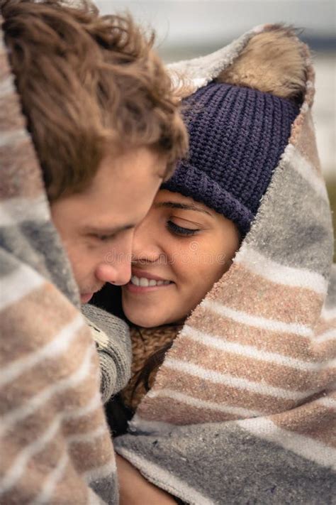 Young Couple Embracing Outdoors Under Blanket In A Stock Image Image