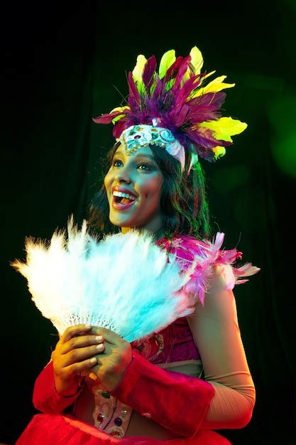 Hermosa mujer joven en máscara de carnaval y disfraz de mascarada en