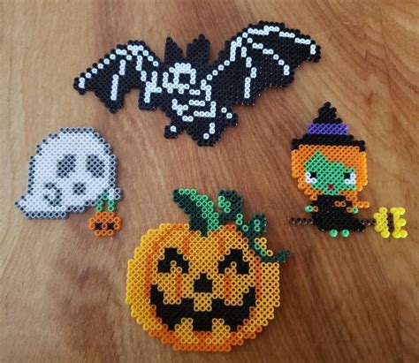 Halloween Decorations Made Out Of Perler Beads On A Wooden Table With