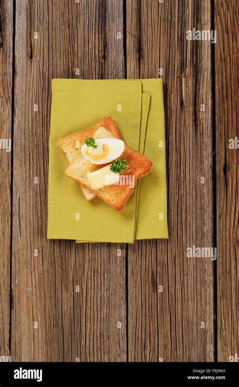 Two pieces of crispy toast, butter and boiled egg Stock Photo - Alamy