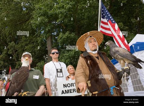 A Japanese Man In Traditional Dress Stands With His Eagle Next To