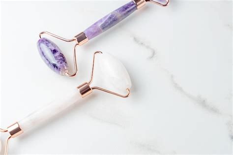 Premium Photo Amethyst And Rose Quartz Massage Rollers On Marble